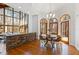 Dining room with modern chandelier, wood floors, stone accent wall, and scenic views from large windows at 301 Stone Currie Dr, Hillsborough, NC 27278