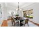 Bright dining room featuring hardwood floors, a modern chandelier, and a large window with beautiful outside views at 301 Stone Currie Dr, Hillsborough, NC 27278