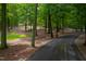 A winding driveway leads through mature trees to a secluded home surrounded by a beautiful canopy of trees at 301 Stone Currie Dr, Hillsborough, NC 27278