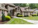 Welcoming stone entrance with landscaped lawn, shrubs, and trees at 301 Stone Currie Dr, Hillsborough, NC 27278