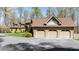 Exterior view of a charming house with a spacious driveway and a three-car garage, all surrounded by lush trees at 301 Stone Currie Dr, Hillsborough, NC 27278