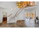 Grand foyer with a curved staircase, soaring ceilings, unique chandelier, and beautiful stone flooring at 301 Stone Currie Dr, Hillsborough, NC 27278