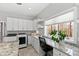 Well-lit laundry room with modern appliances, granite countertops, built-in desk, and views from window at 301 Stone Currie Dr, Hillsborough, NC 27278