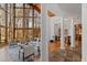 Open-concept living room featuring a wall of windows, stone fireplace, and adjacent columns at 301 Stone Currie Dr, Hillsborough, NC 27278