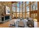 Elegant living room with stone fireplace, floor to ceiling windows, and comfortable seating at 301 Stone Currie Dr, Hillsborough, NC 27278