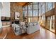 Elegant living room with stone fireplace, floor-to-ceiling windows, and hardwood floors at 301 Stone Currie Dr, Hillsborough, NC 27278