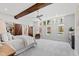 Spacious main bedroom with ceiling fan, beam accents, and ensuite bath, filled with natural light at 301 Stone Currie Dr, Hillsborough, NC 27278