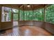 Enjoy this wood paneled porch with a octagon design, wood flooring, a ceiling fan, and views of the lush trees at 301 Stone Currie Dr, Hillsborough, NC 27278