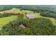 Aerial view with red property line marked, showing house, surrounding meadows, forest and large pond at 301 Stone Currie Dr, Hillsborough, NC 27278