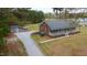 Single-story brick home with welcoming front porch, storage shed, and gravel driveway in wooded setting at 3026 Shoeheel Rd, Kenly, NC 27542