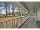 Inviting front porch featuring rocking chairs, overlooking a spacious lawn and serene wooded landscape at 3026 Shoeheel Rd, Kenly, NC 27542