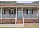 Charming front porch with a baby blue front door, decorative shutters, and hanging flower baskets at 3026 Shoeheel Rd, Kenly, NC 27542