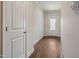 Well-lit hallway with white doors, wood-look flooring, and modern trim, offering a clean and inviting transition space at 303 Azalea Gaze Dr, Youngsville, NC 27596