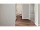 Hallway view with hardwood floors leading to a bathroom and a bedroom with carpet at 303 Azalea Gaze Dr, Youngsville, NC 27596