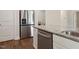 Open kitchen with stainless refrigerator, granite countertops, and stainless dishwasher, washer, and dryer at 303 Azalea Gaze Dr, Youngsville, NC 27596