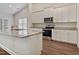 Well-lit kitchen with granite island, stainless steel appliances, and white cabinets, ideal for cooking and entertaining at 303 Azalea Gaze Dr, Youngsville, NC 27596