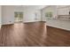 Spacious living area with wood-look flooring, large windows, and kitchen access, ideal for entertaining and comfortable living at 303 Azalea Gaze Dr, Youngsville, NC 27596