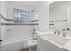 Bright bathroom features white tile, glass block window, and modern vanity with marble countertop at 306 Cecil St, Durham, NC 27707