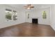 Bright and airy living room with large windows, a cozy fireplace, and modern ceiling fan at 306 Cecil St, Durham, NC 27707