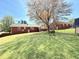 Expansive backyard with lush green lawn and shade trees, perfect for recreation and outdoor activities at 310 Meadowbrook Dr, Burlington, NC 27215