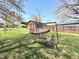 Backyard view showcasing a storage shed, swing and green grass; an ideal outdoor retreat for relaxing and enjoying nature at 310 Meadowbrook Dr, Burlington, NC 27215