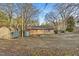 A single story brick home featuring a large backyard and a shed with unique doors and trim at 3416 North Ridge Dr, Sanford, NC 27330