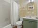 Full bathroom featuring shower-tub combo, vintage wallpaper, and a green vanity at 3416 North Ridge Dr, Sanford, NC 27330