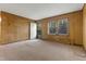 Well-lit living room showcasing paneled walls, carpet floors, and a front-facing window at 3416 North Ridge Dr, Sanford, NC 27330