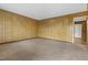 Cozy living room with paneled walls and carpet, leading to the entry hallway at 3416 North Ridge Dr, Sanford, NC 27330
