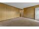 Spacious living room featuring paneled walls, carpet flooring, and a view of the entry hallway at 3416 North Ridge Dr, Sanford, NC 27330