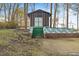 A shed with a green foundation and steps, a brick foundation, and trees at 3416 North Ridge Dr, Sanford, NC 27330