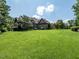 Expansive backyard with lush green lawn, mature trees, and a charming brick home providing privacy and space at 3505 Jonaway Cir, Fuquay Varina, NC 27526