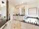 Elegant bathroom with dual sinks, vanity, marble countertop, and luxurious soaking tub at 3505 Jonaway Cir, Fuquay Varina, NC 27526