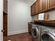 Functional laundry room with wooden cabinets, granite countertops, and modern washer and dryer at 3505 Jonaway Cir, Fuquay Varina, NC 27526
