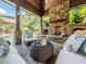 Comfortable outdoor living space with a stone fireplace, plush seating, and serene views of the backyard at 3505 Jonaway Cir, Fuquay Varina, NC 27526
