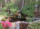 Backyard pond with rocks, waterfall, and lush vegetation at 3537 Layton Ridge Dr, Apex, NC 27539