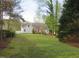 Spacious backyard with mature trees, lush lawn, and views of home at 3537 Layton Ridge Dr, Apex, NC 27539