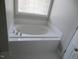 Bright bathroom featuring soaking tub with chrome fixtures and a window above at 3537 Layton Ridge Dr, Apex, NC 27539