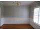 Classic dining room with hardwood floors, wainscoting, and elegant chandelier lighting at 3537 Layton Ridge Dr, Apex, NC 27539