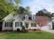 Charming white two-story home with a well-manicured lawn and flowering tree at 3537 Layton Ridge Dr, Apex, NC 27539