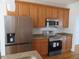 Modern kitchen with stainless steel appliances, wooden cabinets, and granite countertops at 3537 Layton Ridge Dr, Apex, NC 27539