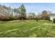 Expansive backyard with vibrant landscaping and mature trees, creating a serene outdoor space at 408 Indian Elm Ln, Cary, NC 27519