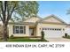 Charming single-story home with a two-car garage, manicured lawn, and inviting front entrance at 408 Indian Elm Ln, Cary, NC 27519