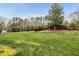 Manicured front yard with lush lawn, mature trees, and well-maintained landscaping at 408 Indian Elm Ln, Cary, NC 27519