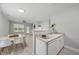 Bright kitchen with stainless steel sink, white cabinets and dining area with a view of the living room at 408 Indian Elm Ln, Cary, NC 27519