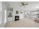 Open-concept living room with fireplace, built-in shelving, neutral tones, and breakfast bar at 408 Indian Elm Ln, Cary, NC 27519