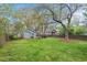 Spacious backyard with lush lawn, mature trees, and a patio with dining set at 410 N Hyde Park Ave, Durham, NC 27703