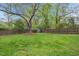 View of a spacious, fenced backyard featuring a storage shed and mature trees at 410 N Hyde Park Ave, Durham, NC 27703