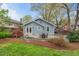 Charming home with a stone patio surrounded by colorful landscaping and lush lawn at 410 N Hyde Park Ave, Durham, NC 27703