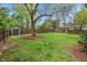 Large backyard with mature trees, lush lawn, and storage shed at 410 N Hyde Park Ave, Durham, NC 27703